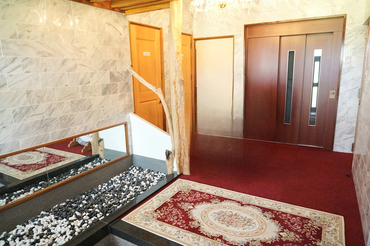 天然石を使用した玄関まわりで、玄関奥にはホームエレベーターを備えております。